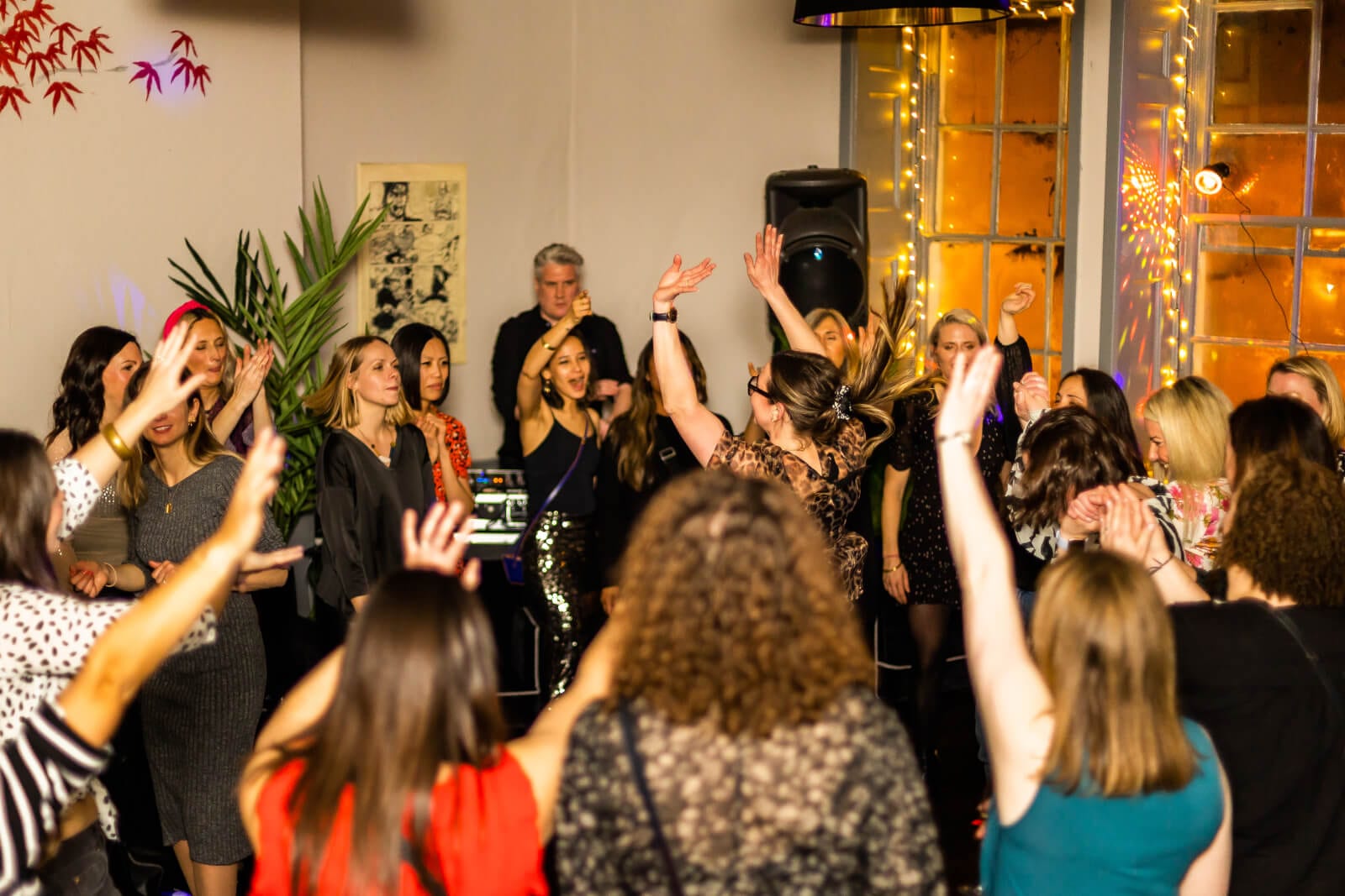 A karaoke party in full voice, arms in the air