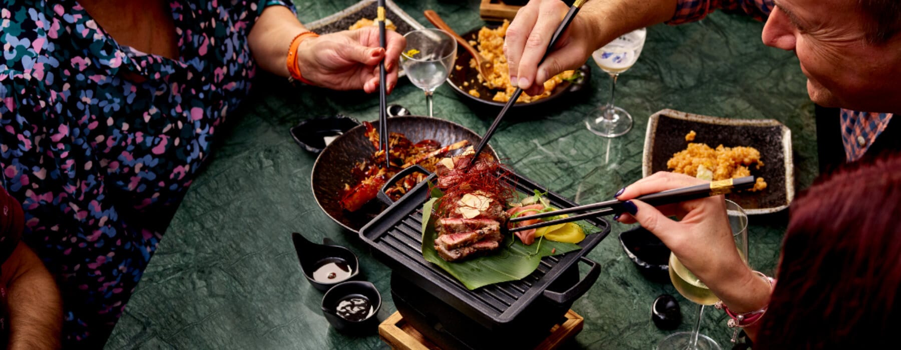 Robata plates and skewers across a dark table